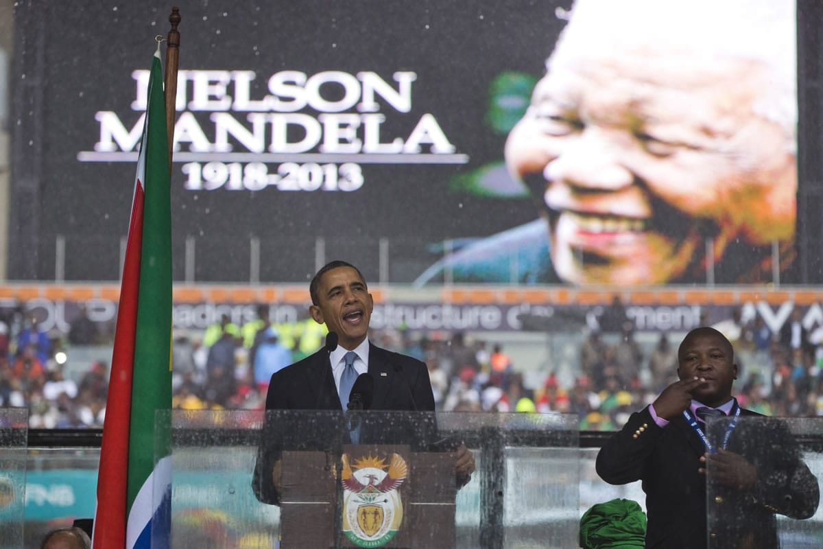 President Barack Obama delivers his speech next to a sign language interpreter during a memorial service at FNB Stadium in honor of Nelson Mandela on Tuesday in Soweto, near Johannesburg.