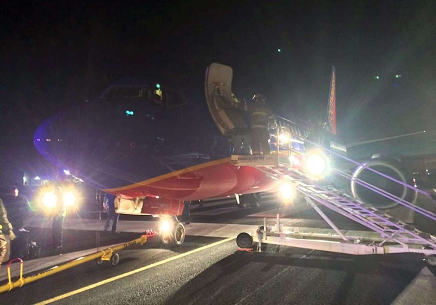 Rescue personnel help passengers off a Southwest Airlines flight that was supposed to land at Branson Airport in Branson, Mo., but instead landed at Taney County Airport, in Hollister, Mo., that only has about half as much runway.