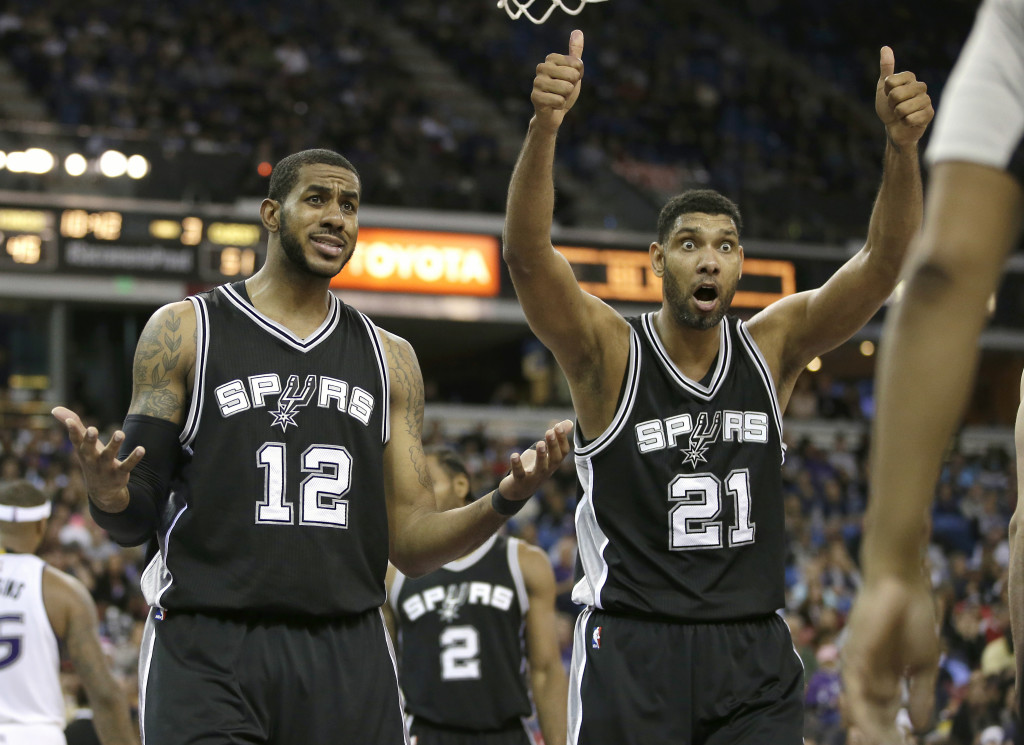 San Antonio Spurs' LaMarcus Aldridge, left, and Tim Duncan, question official Bennie Adams after he called Aldridge for a foul during the second half of an NBA basketball game against the Sacramento Kings in Sacramento, Calif., on Monday.