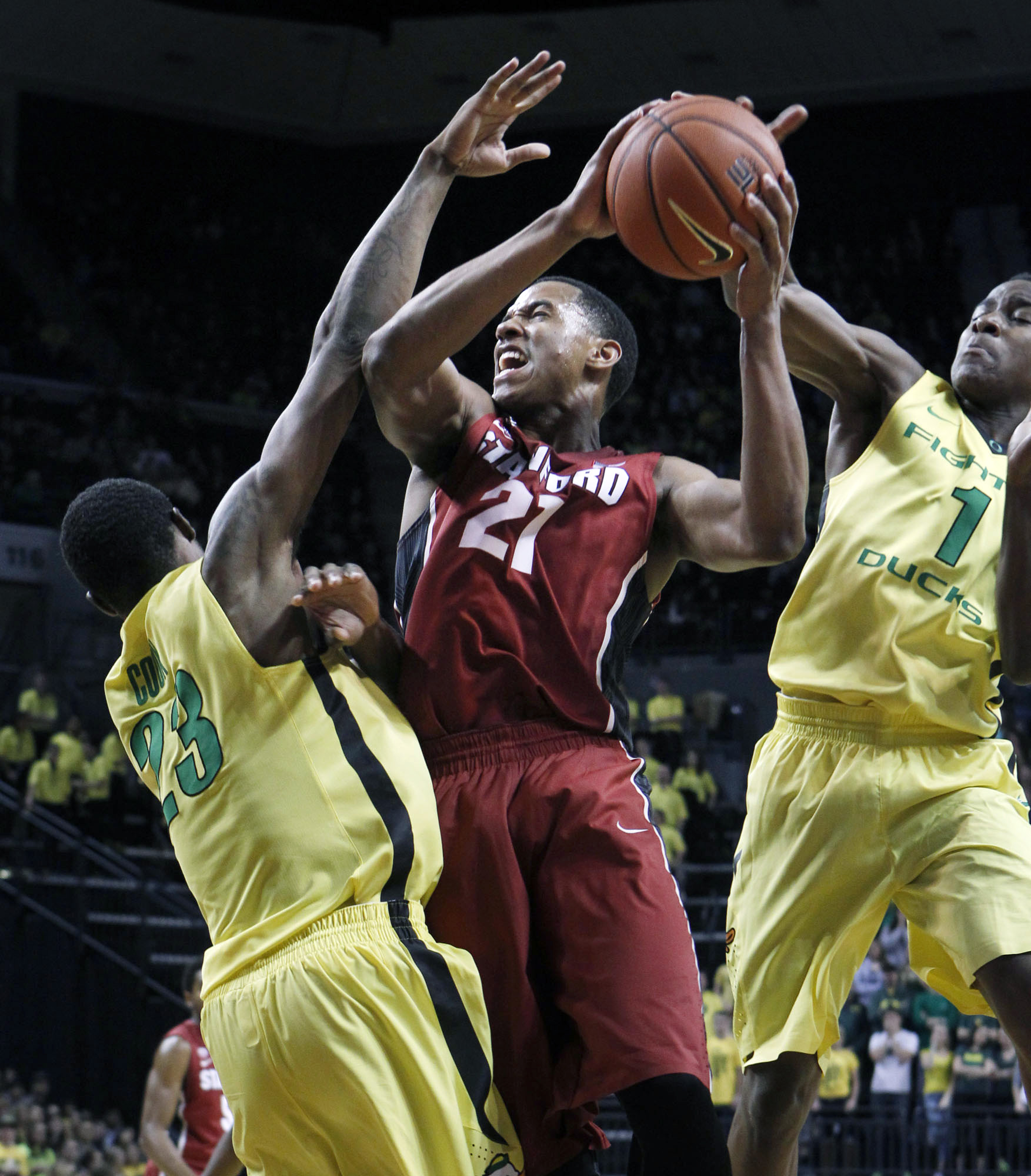 Stanford's Anthony Brown, center, drives between Oregon's Elgin Cook, left, and Dominic Artis, right, during the first half Sunday.