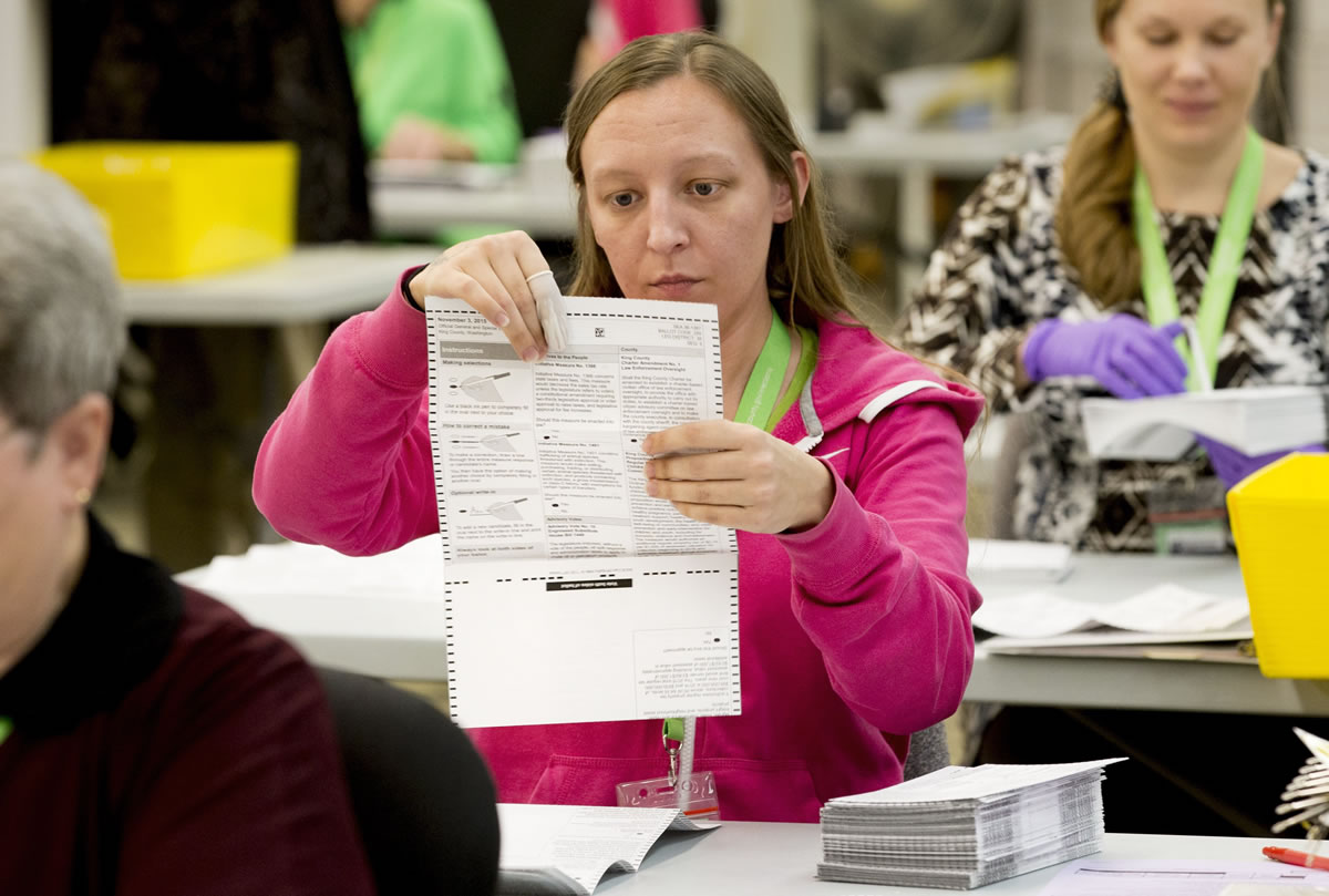 Election workers, including Brianna Michel, center, sort through ballots at the King County Elections Office on election day Tuesday in Renton.