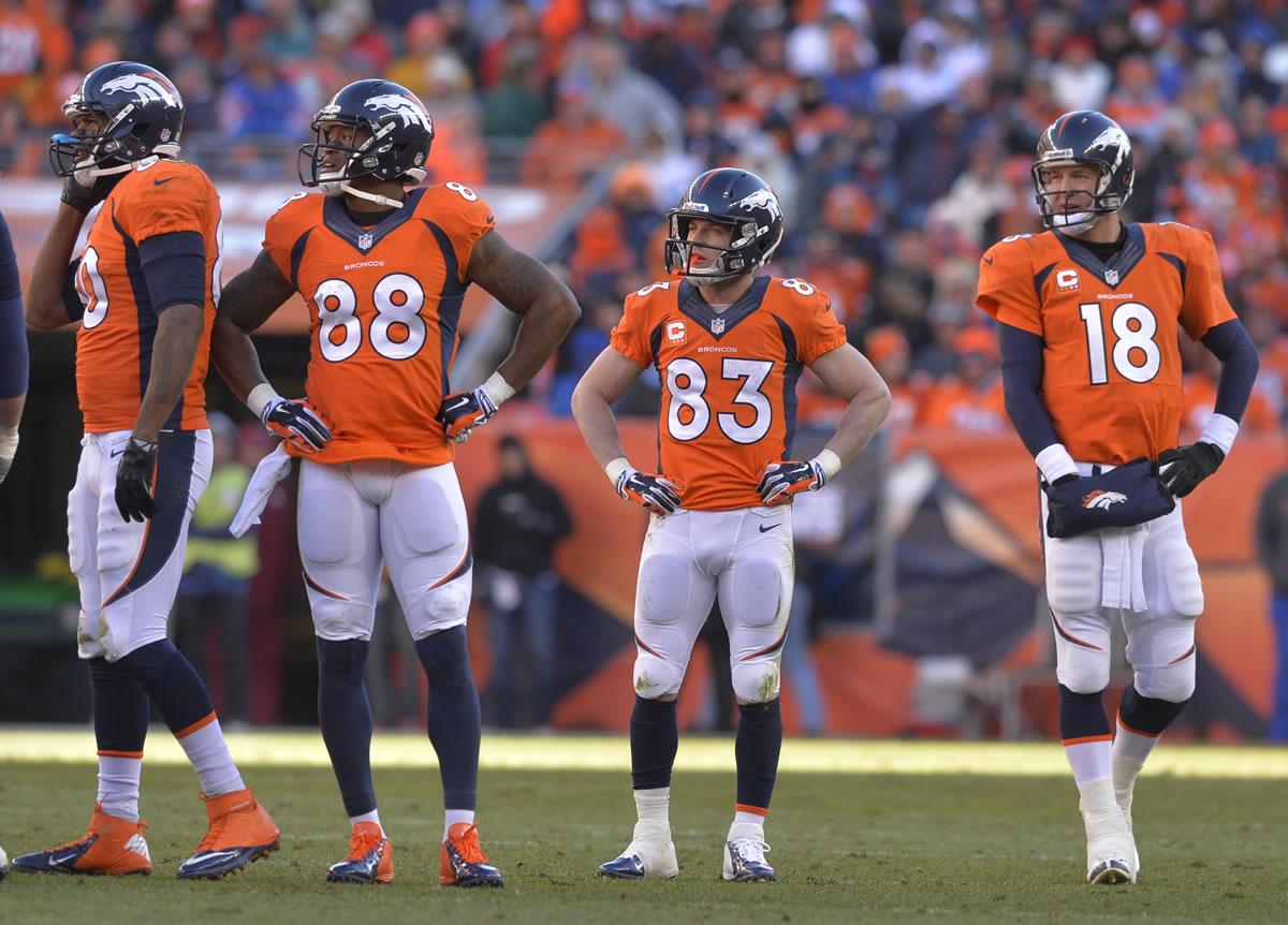 ADVANCE FOR WEEKEND EDITIONS, JAN. 25-26 - In this Jan. 12, 2014, file photo, Denver Broncos tight end Julius Thomas (80), wide receiver Demaryius Thomas (88), wide receiver Wes Welker (83) and quarterback Peyton Manning (18) wait as officials review a fumbled pass by Thomas during the second quarter against the San Diego Chargers in an AFC divisional NFL playoff football game in Denver.  No team in the 93-year history of the NFL ever had that many players catch at least 60 passes or reach the end zone 10 or more times until the Broncos put up a record 606 points.