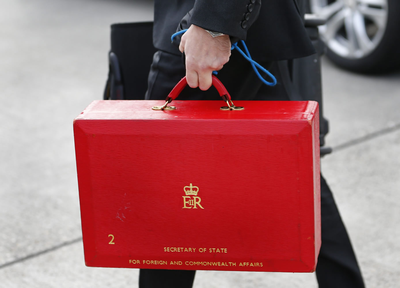 An staff carries a red case Saturday after British Foreign Secretary William Hague arrival at Geneva International airport in Geneva, Switzerland. U.S.