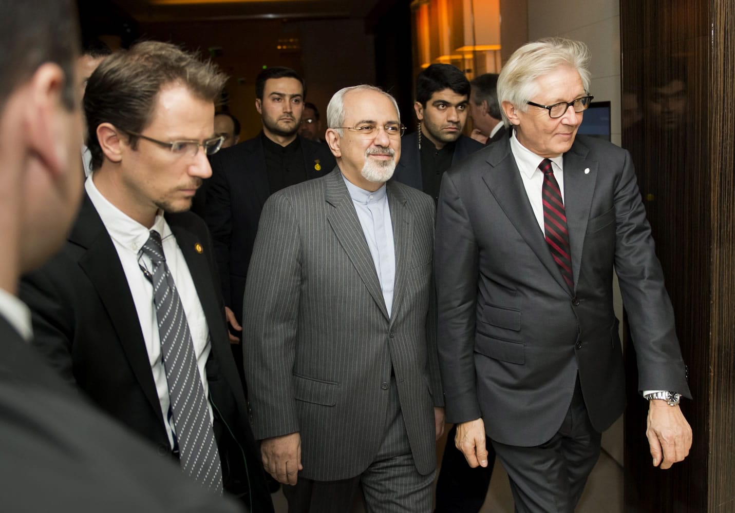 Iranian Foreign Minister Mohammad Javad Zarif, center, makes his way to a meeting Saturday, the third day of closed-door nuclear talks in Geneva.