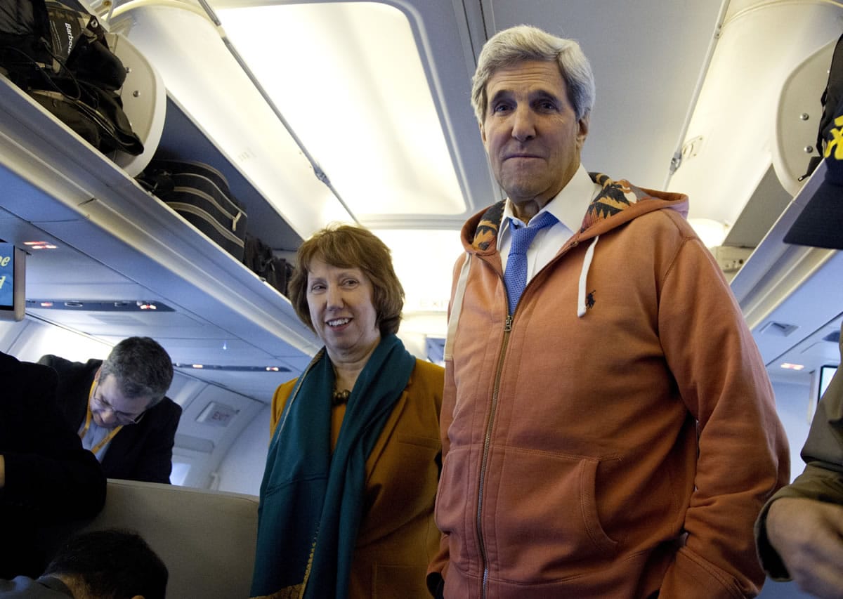U.S. Secretary of State John Kerry, right, and EU foreign policy chief Catherine Ashton, left, visit the media seating area of Kerry's aircraft as it sits on the tarmac at Geneva International airport before leaving for London on Sunday from Geneva, Switzerland.