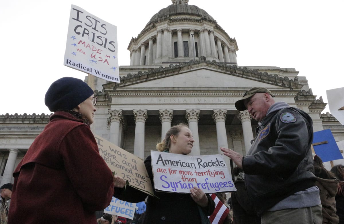 Protesters on opposing sides of the Syrian refugee resettlement issue rally Friday in front of the state Capitol in Olympia. Gov. Jay Inslee has said the state will welcome refugees and has criticized other governors who have threatened to stop accepting them.