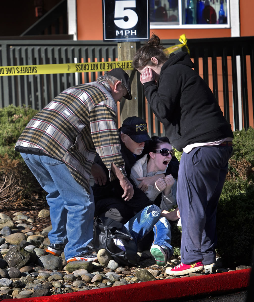 An official comforts the mother, of a two-year-old child that was killed at an apartment complexWednesday in Tacoma.