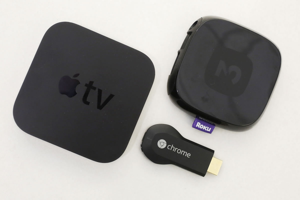 An Apple TV device, top, Google's Chromecast, left, and the Roku 3 are among the devices that project video from Netflix, YouTube and other services onto a big-screen TV.