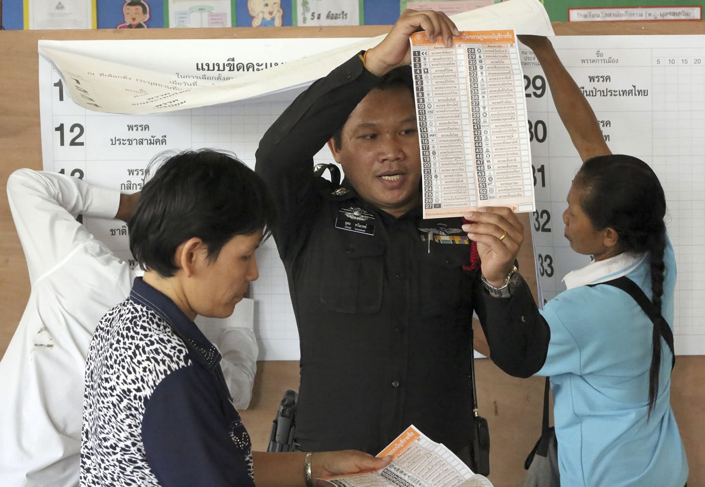 A Thai policeman reads a ballot during a vote counting Sunday after the general election in Bangkok.
