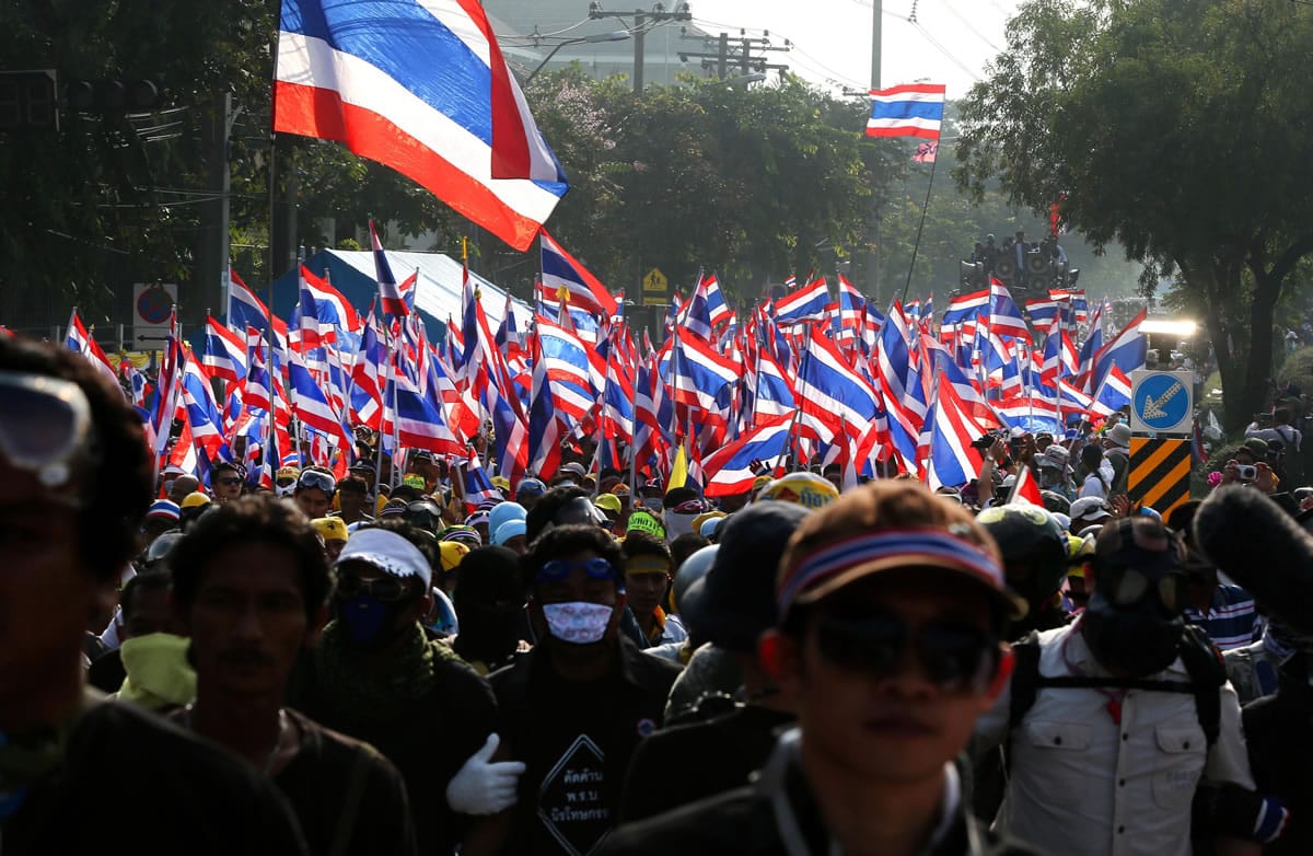Anti government protesters march outside Government house, which houses Thailand prime minister Yingluck Shinawatra office, in Bangkok, Thailand, on Monday.