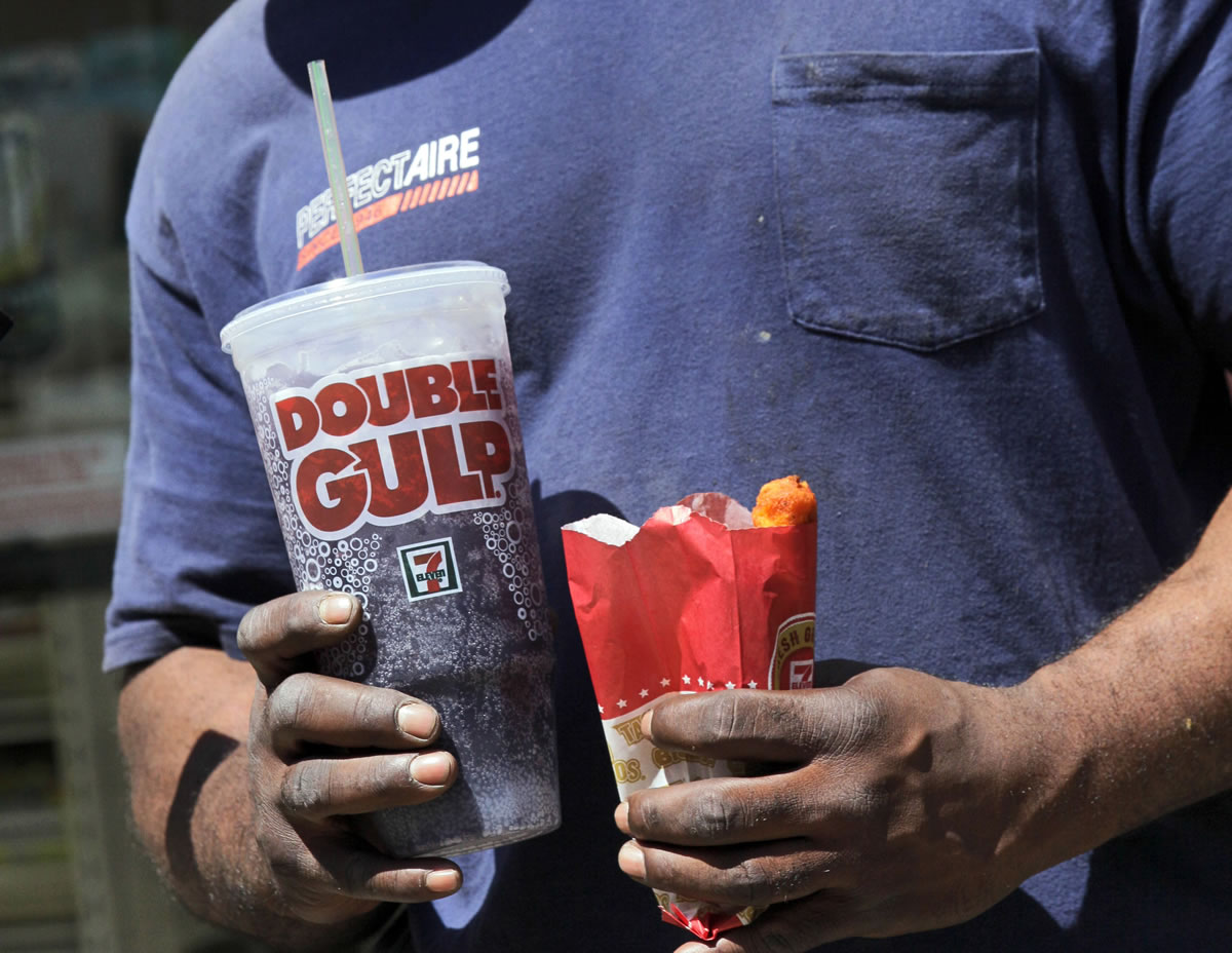 Files/Associated Press
A man leaves a 7-Eleven store with a Double Gulp drink in New York. Mayor Michael Bloomberg's attempt to stop restaurants from selling sodas larger than 16 ounces caused more of an uproar than the trans fat ban.