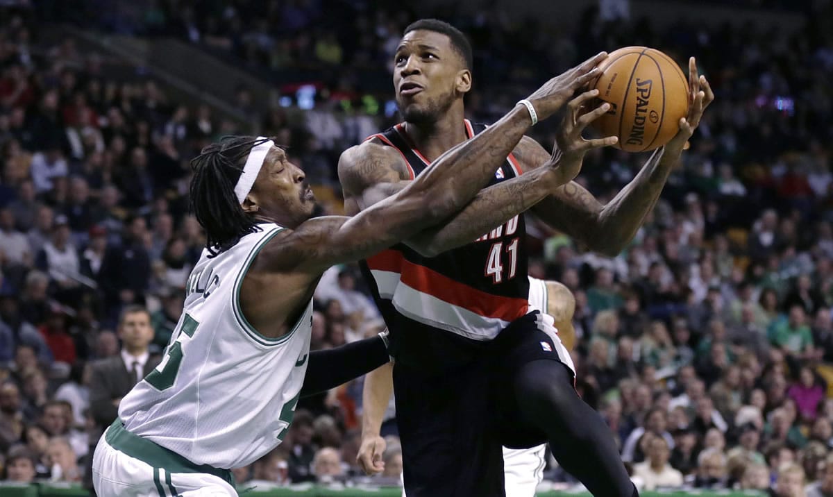 Boston Celtics forward Gerald Wallace, left, tries to knock the ball away from Portland Trail Blazers power forward Thomas Robinson (41) on a drive to the basket during the second half of an NBA basketball game in Boston, Friday, Nov. 15, 2013. The Trail Blazers won 109-96.