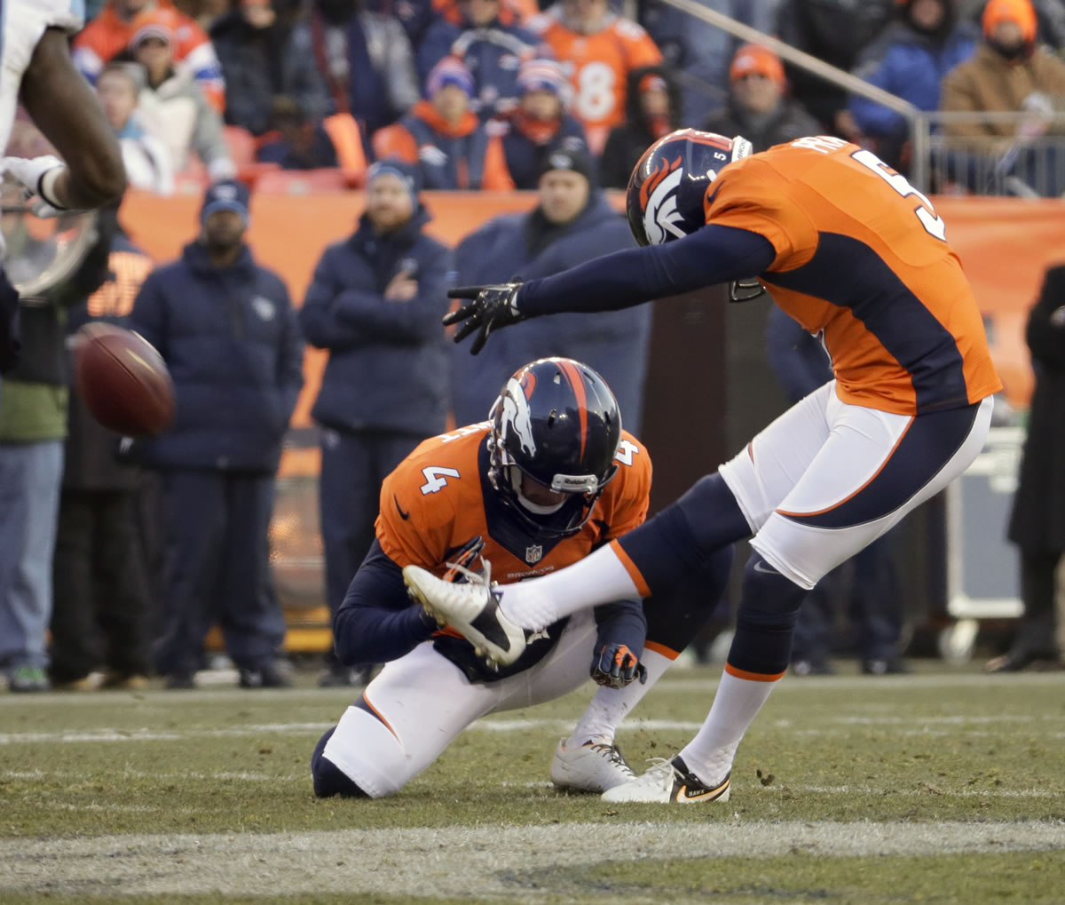 Denver Broncos kicker Matt Prater, right, kicks a 64-yard field goal as Britton Colquitt holds during the first half of an NFL football game against the Tennessee Titans on Sunday, Dec. 8, 2013, in Denver.