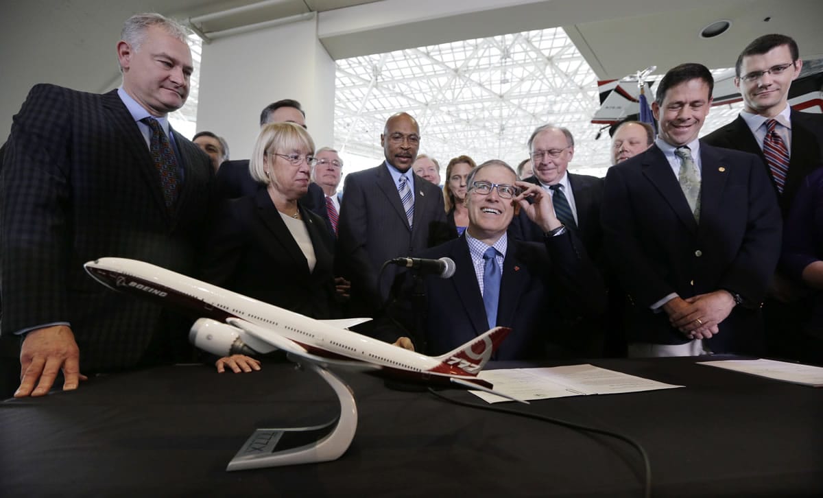 Associated Press files
Gov. Jay Inslee signs legislation with $9 billion in tax incentives to help keep production of Boeing's new 777X in Washington.
