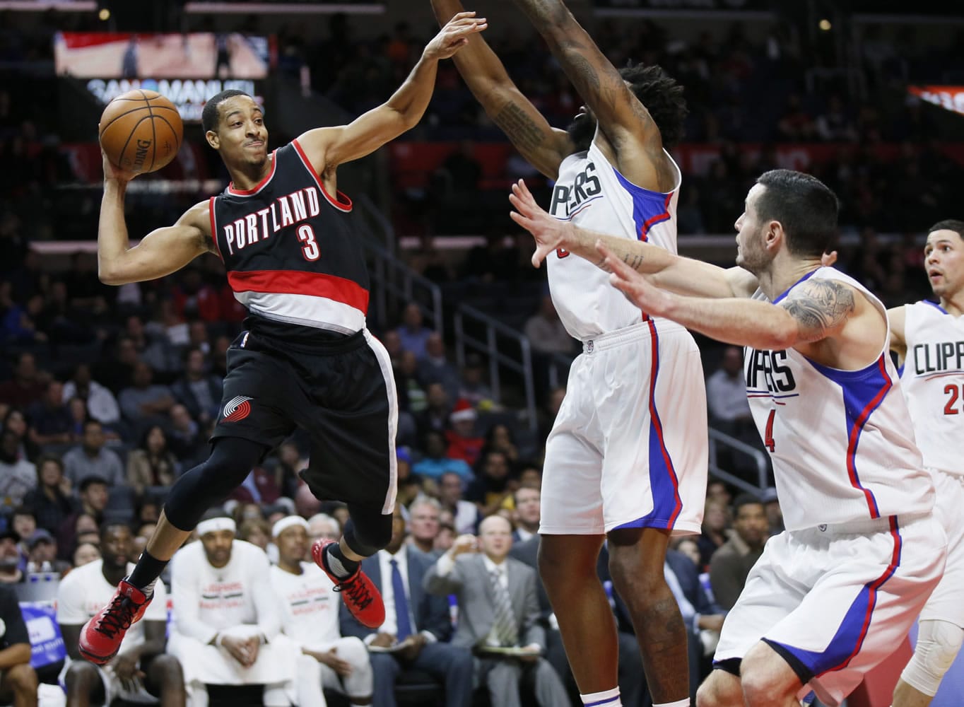 Portland Trail Blazers&#039; C.J. McCollum, left, looks to pass as Los Angeles Clippers&#039; DeAndre Jordan, center, and Clippers&#039; J.J. Redick, right, defends during the second half of an NBA basketball game, Monday, Nov. 30, 2015, in Los Angeles. The Clippers on 102-87.