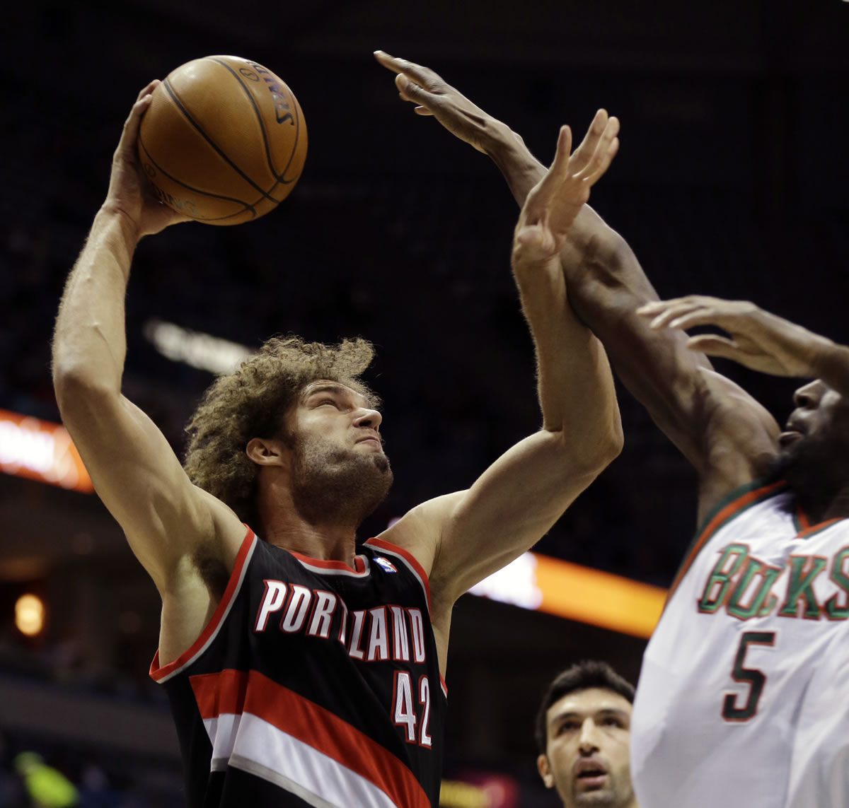 Portland Trail blazers' Robin Lopez (42) goes up for a shot against the Milwaukee Bucks' Ekpe Udoh, right, during the first half of an NBA basketball game on Wednesday, Nov. 20, 2013, in Milwaukee.