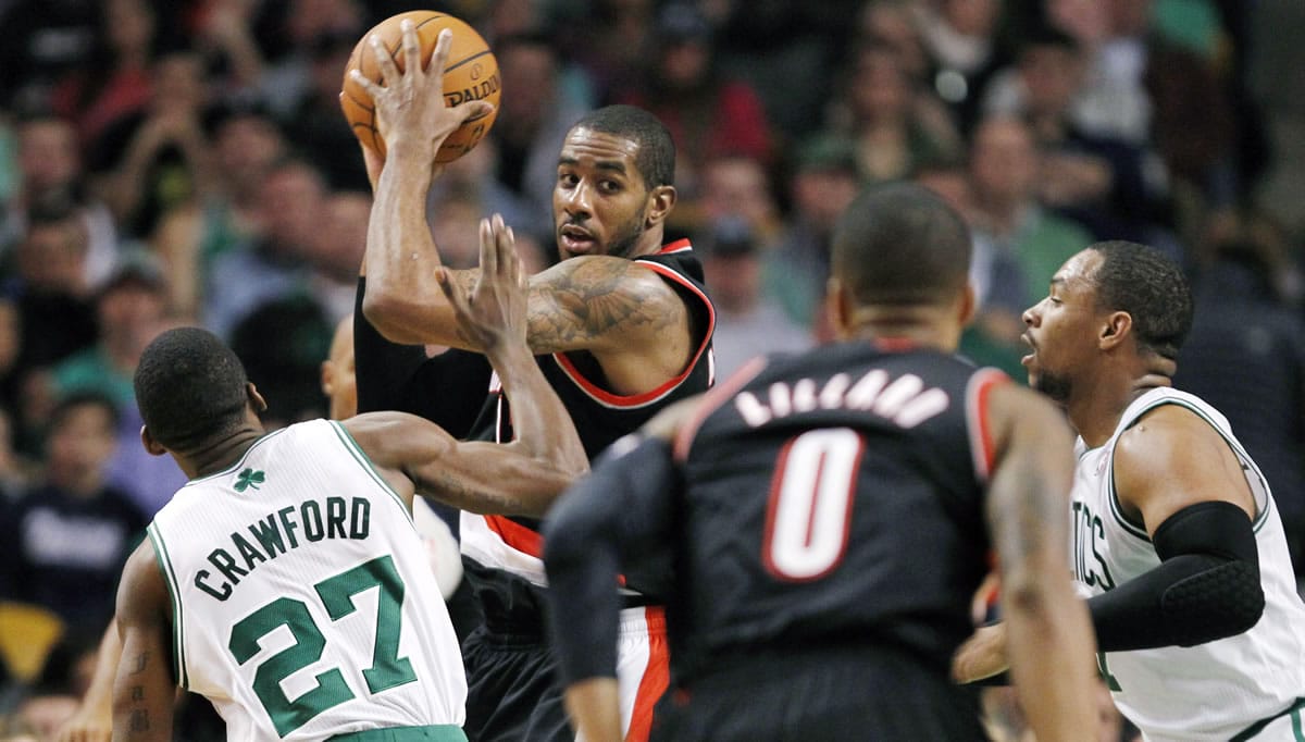 Portland Trail Blazers forward LaMarcus Aldridge, second from left, looks to pass while covered by Boston Celtics guard Jordan Crawford (27) and Jared Sullinger, right, during the second quarter Friday.