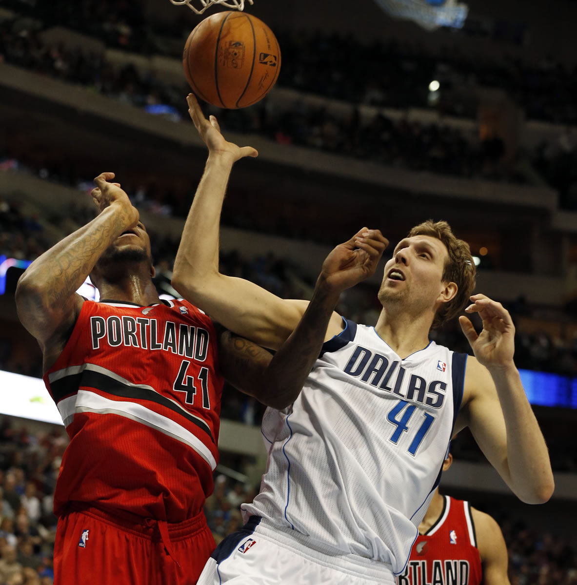 Portland Trail Blazers forward Thomas Robinson, left, and Dallas Mavericks forward Dirk Nowitzki, right, of Germany, fight for a loose ball during the first half of an NBA basketball game on Friday, March 7, 2014, in Dallas. (AP Photo/John F.