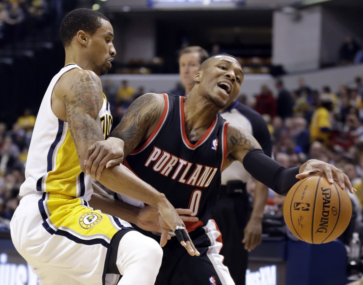 Portland Trail Blazers guard Damian Lillard, right, works against Indiana Pacers guard George Hill during the first half at Indianapolis on Friday.