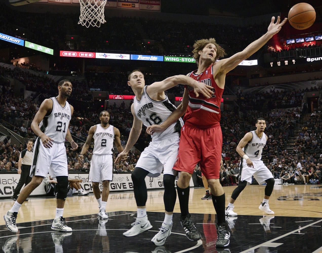Portland Trail Blazers center Robin Lopez, right, and San Antonio Spurs forward Aron Baynes (16) watch a loose ball during the second half Wednesday in San Antonio.