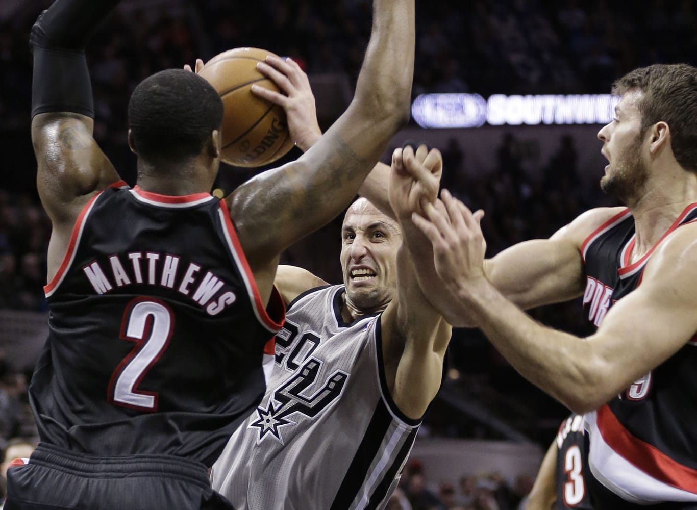 San Antonio Spurs' Manu Ginobili (20) is fouled as he drives between Portland Trail Blazers' Wesley Matthews (2) and Joel Freeland, right, during the first half Friday.
