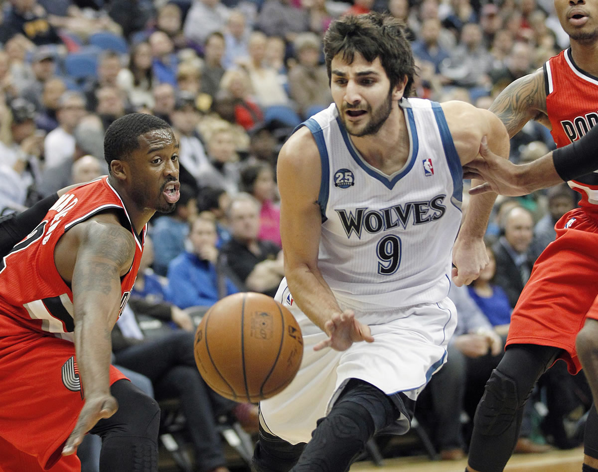 Minnesota Timberwolves guard Ricky Rubio (9) squeezes through pressure defense by Portland Trail Blazers Wesley Matthews, left, in the first quarter Saturday.
