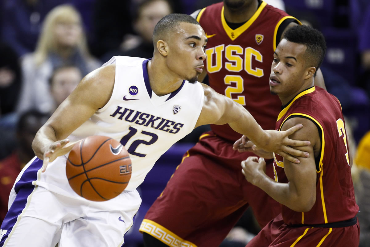 Washington guard Andrew Andrews (12) dribbles past Southern California guard Chass Bryan (3) during the first half of an NCAA college basketball game, Saturda in Seattle.