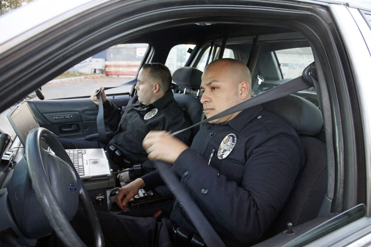 Nick Ut/Associated Press
Los Angeles police officers Adrian Garcia, right, and his partner Christopher Ballerini buckle their seat belts Tuesday as they prepare to leave the LAPD's Pacific Division for patrol in Los Angeles.
