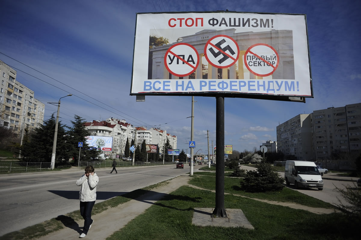 A resident walks by a poster reading &quot;Stop fascism!
