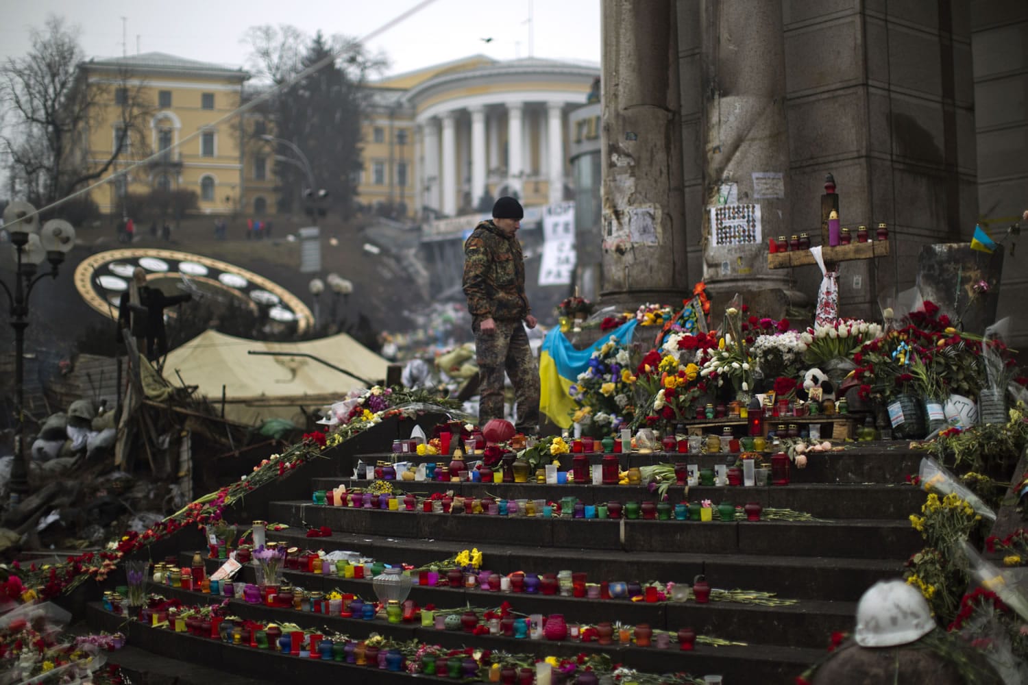 An anti-Yanukovych protester stands at a memorial for the people killed in clashes with the police at Kiev's Independence Square, the epicenter of the country's current unrest, on Saturday.