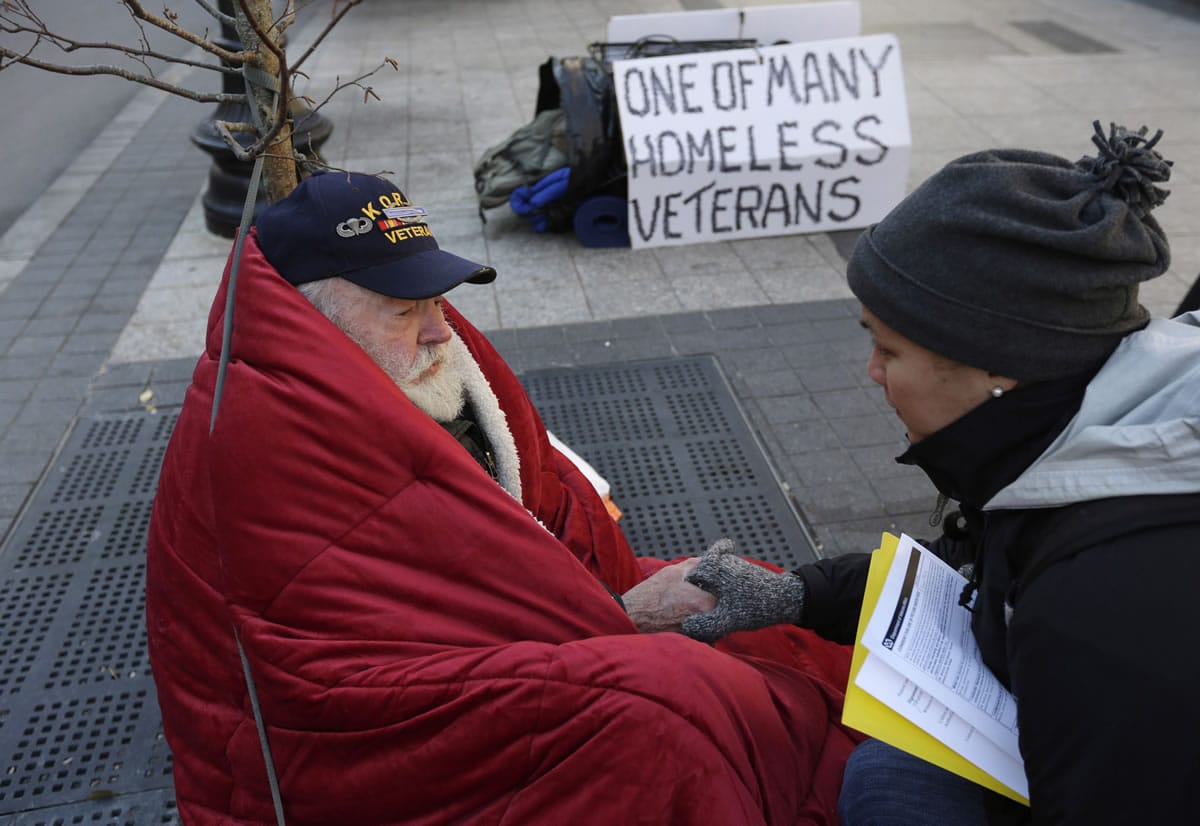 Homeless Korean War veteran Thomas Moore, 79, left, speaks with Boston Health Care for the Homeless street team outreach coordinator Romeena Lee last month on a sidewalk in Boston.