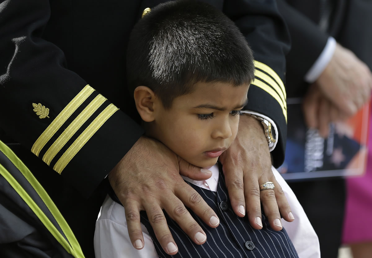 Christian Albornoz, 4, stands with his father Cmdr. Julio Albornoz during a Veterans Day ceremony at the University of Miami on Monday in Coral Gables, Fla.