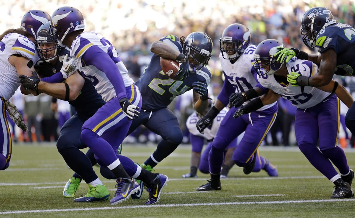 Seattle Seahawks' Marshawn Lynch (24) finds a hole as he heads to score against the Minnesota Vikings in the first half of an NFL football game Sunday, Nov. 17, 2013, in Seattle. (AP Photo/Ted S.