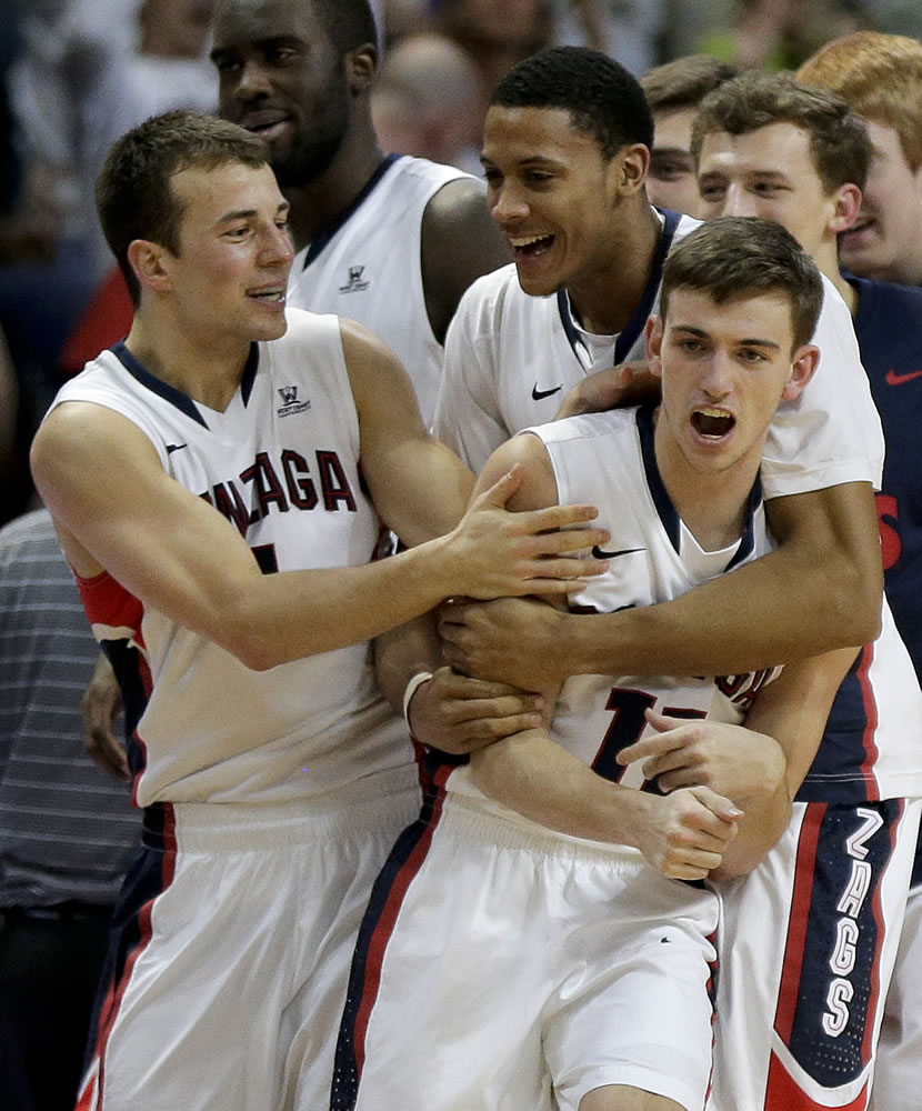 Gonzaga's David Stockton, right, is mobbed by teammates at the end of a quarterfinal West Coast Conference NCAA college basketball tournament game against Santa Clara, Saturday, March 8, 2014, in Las Vegas. Stockton hit a basket to put Gonzaga up by two points with one second left on the clock. Gonzaga won 77-75.