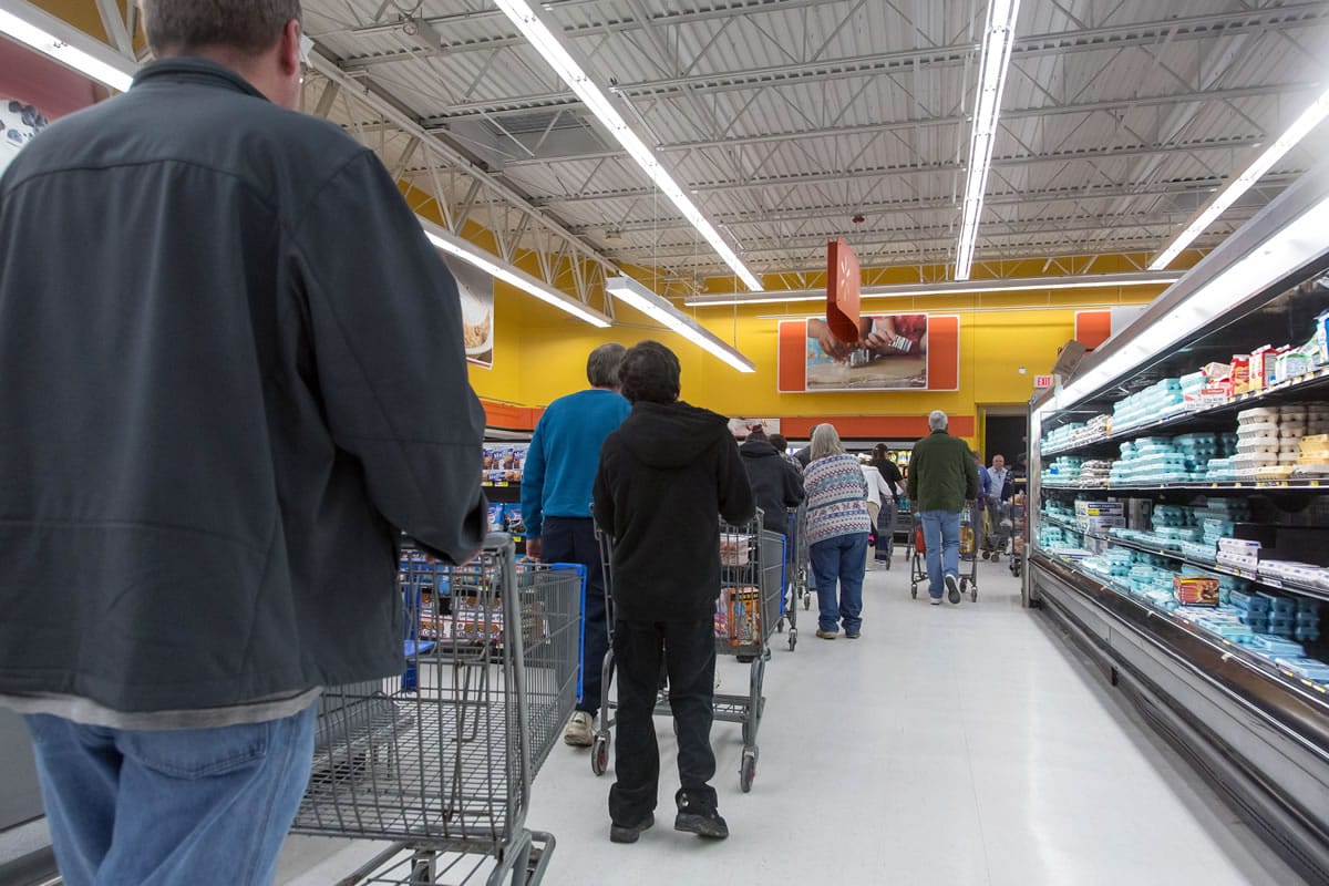 People wait in a line to stock up on bottled water Saturday at a supermarket in Charleston, W.Va.
