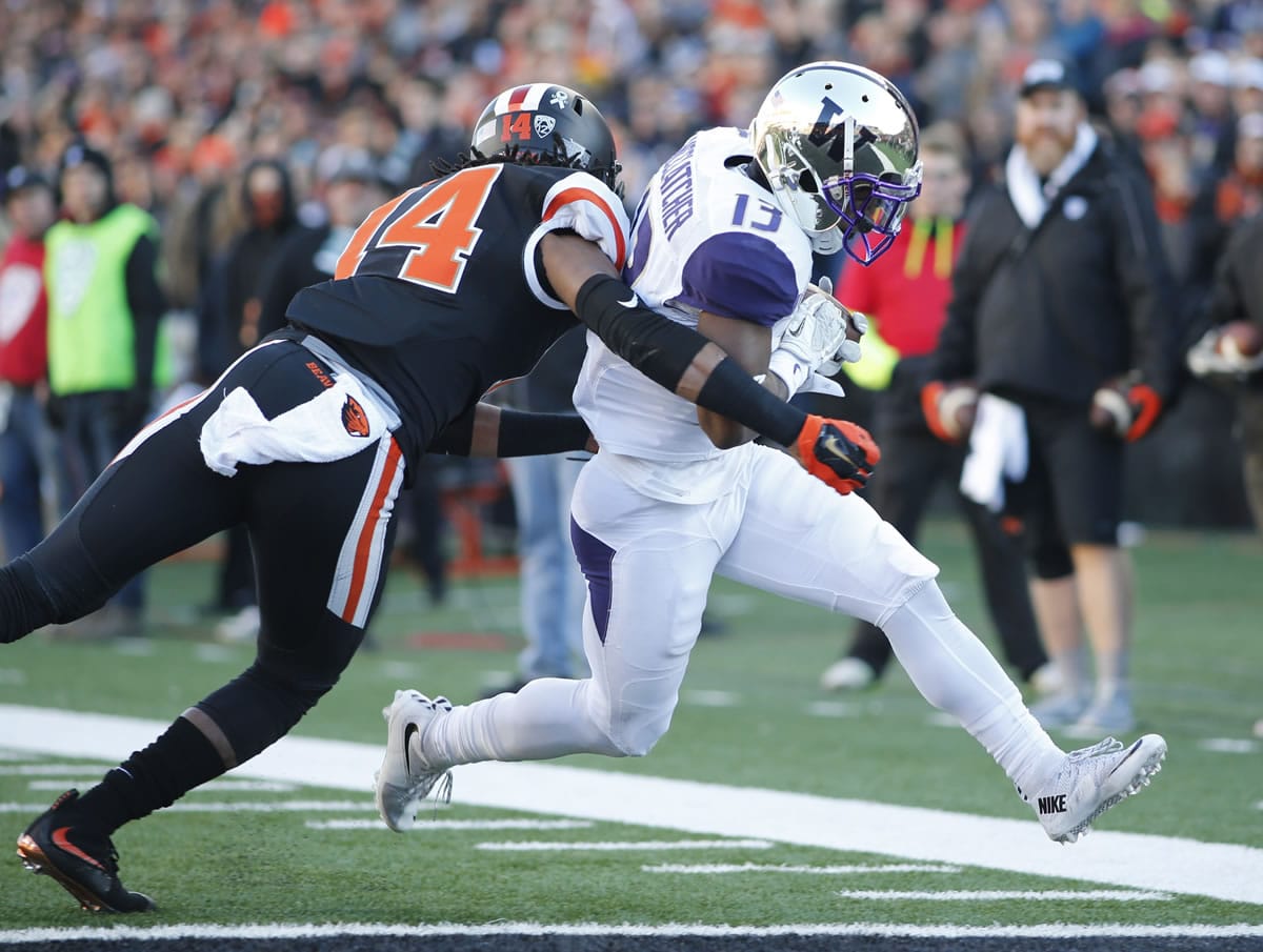 Washington's Chico McCatcher, right, gets around Oregon State's Treston Decoud for a touchdown during the first half in Corvallis, Ore., on Saturday, Nov. 21, 2015. (AP Photo/Timothy J.