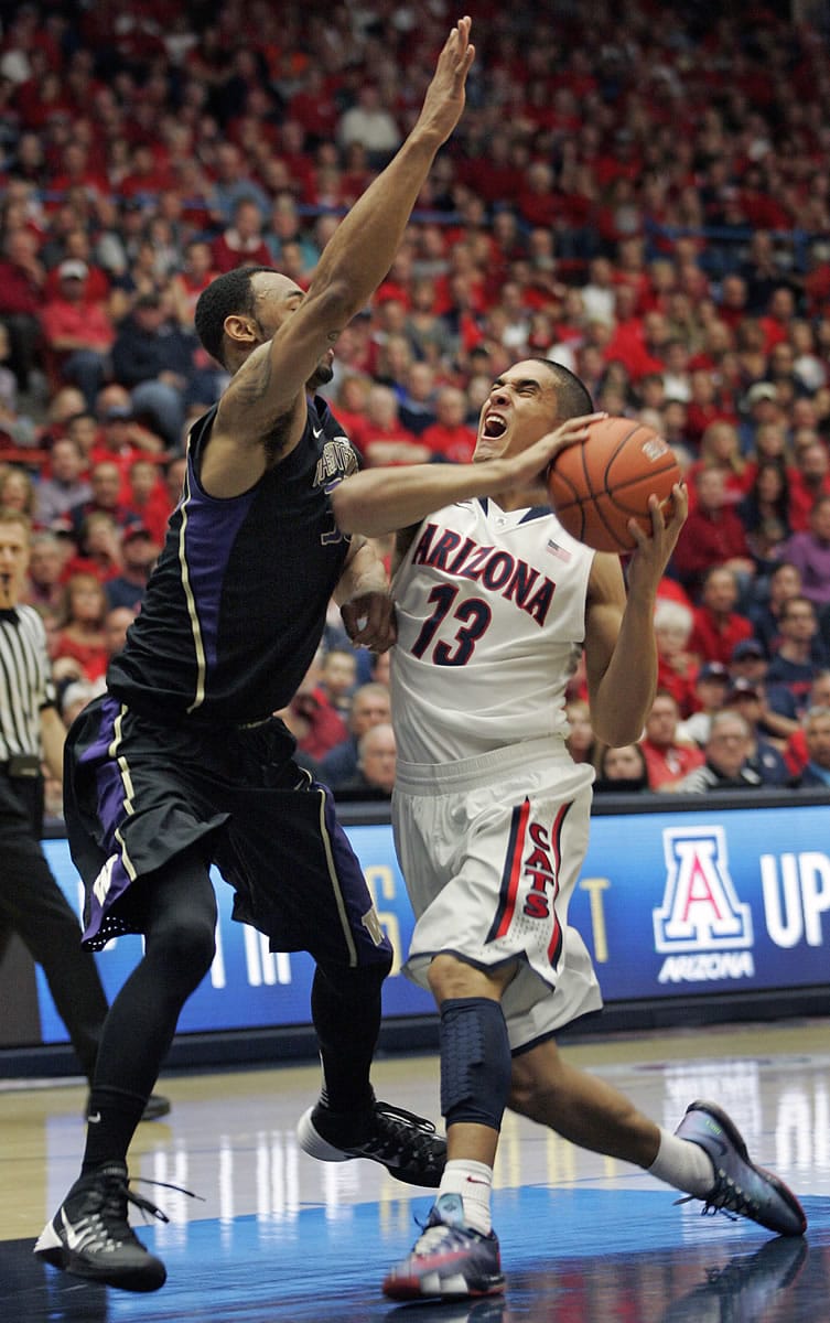 Arizona's Nick Johnson (13) tries to shoot against the pressing defense of Washington's Desmond Simmons, left, in the first half of Saturday's Pac-12 Conference game at Tucson, Ariz.