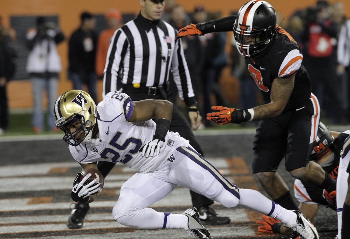 Washington running back Bishop Sankey, left, dives in for a touchdown past Oregon State defender Tyrequek Zimmerman during the first half of an NCAA college football game in Corvallis, Ore., Saturday, Nov. 23, 2013.