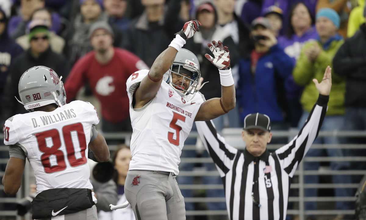 Washington State's Rickey Galvin (5) celebrates his 14-yard touchdown reception with Dom Williams as official Bernie Hulscher signals the score in the first half Friday.