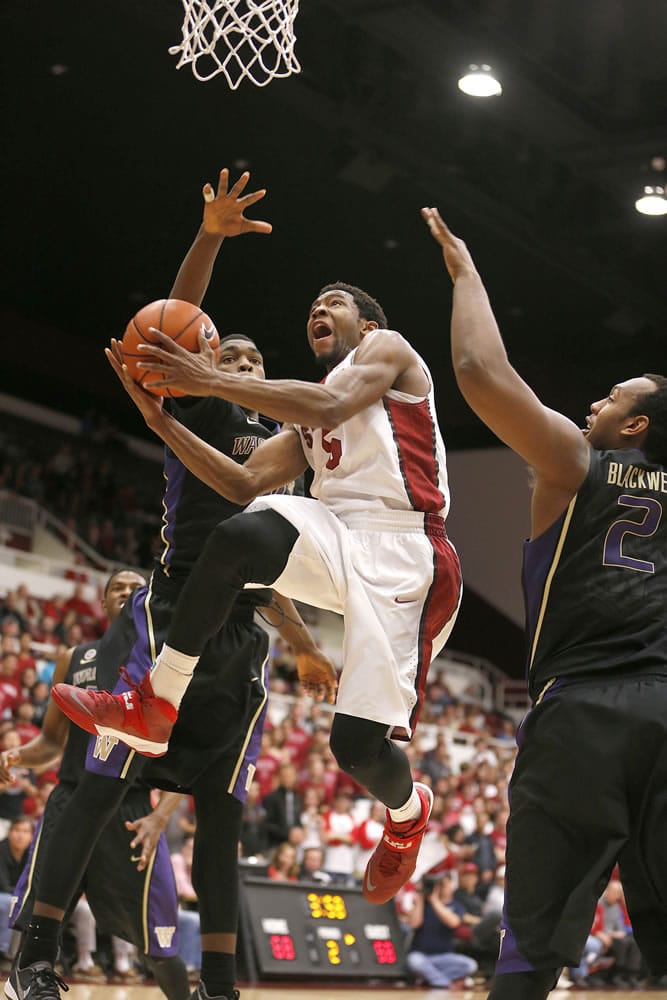Stanford's Chasson Randle (5) drives to the basket against Washington's Mike Anderson, left, and Perris Blackwell (2) during the second half Saturday at Stanford, Calif. Stanford won 79-67.