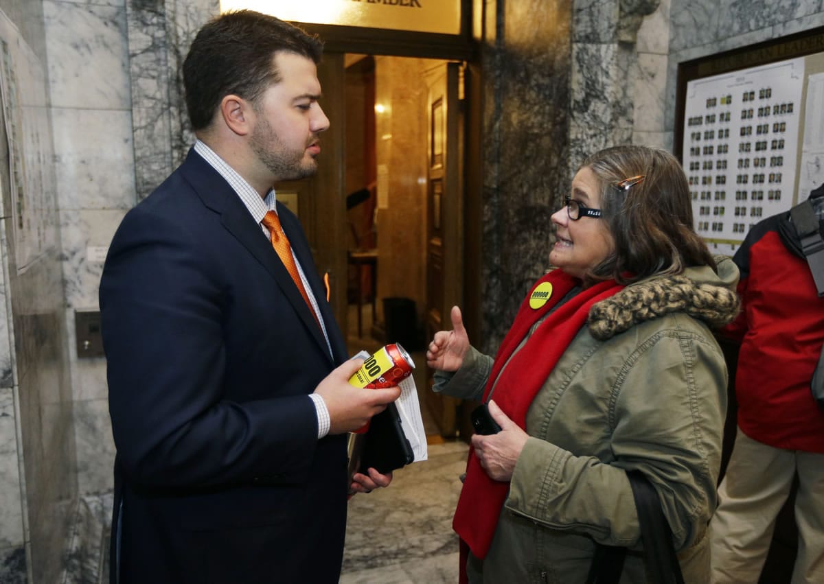 Linda Peterson, right, a teacher from Battle Ground, talks with Rep. Brandon Vick, R-Vancouver, on Monday in Olympia on the first day of the 2014 session.