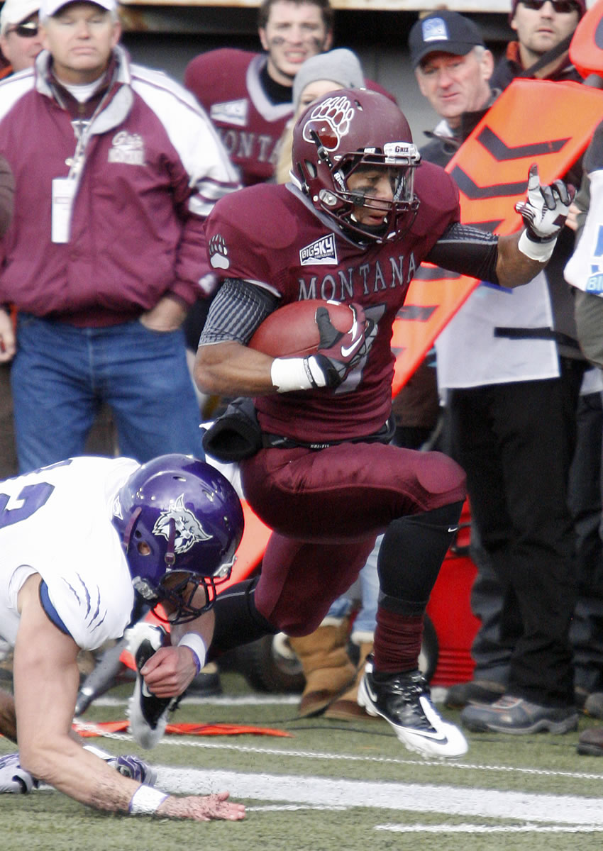 Montana wide receiver Ellis Henderson (7) runs past a Weber State defensive back after catching a pass in the third quarter of an NCAA college football game in Missoula, Mont., Saturday, Nov. 16, 2013.