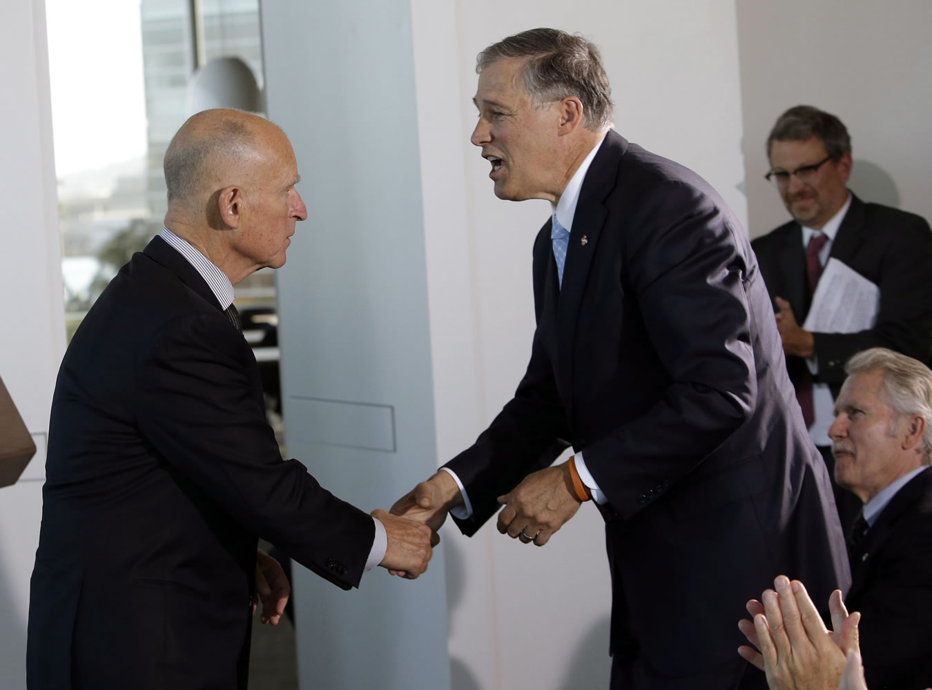 Washington Gov. Jay Inslee, right, shake hands with California Gov. Jerry Brown before they signed an agreement with Oregon Gov. John Kitzhaber and Mary Polak, a representative of the premier of British Columbia, to collectively combat climate change on Oct.
