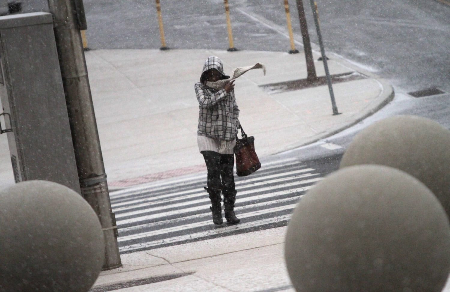 A pedestrian bundles up as snow begins to fall Tuesday in Wilmington, Del.