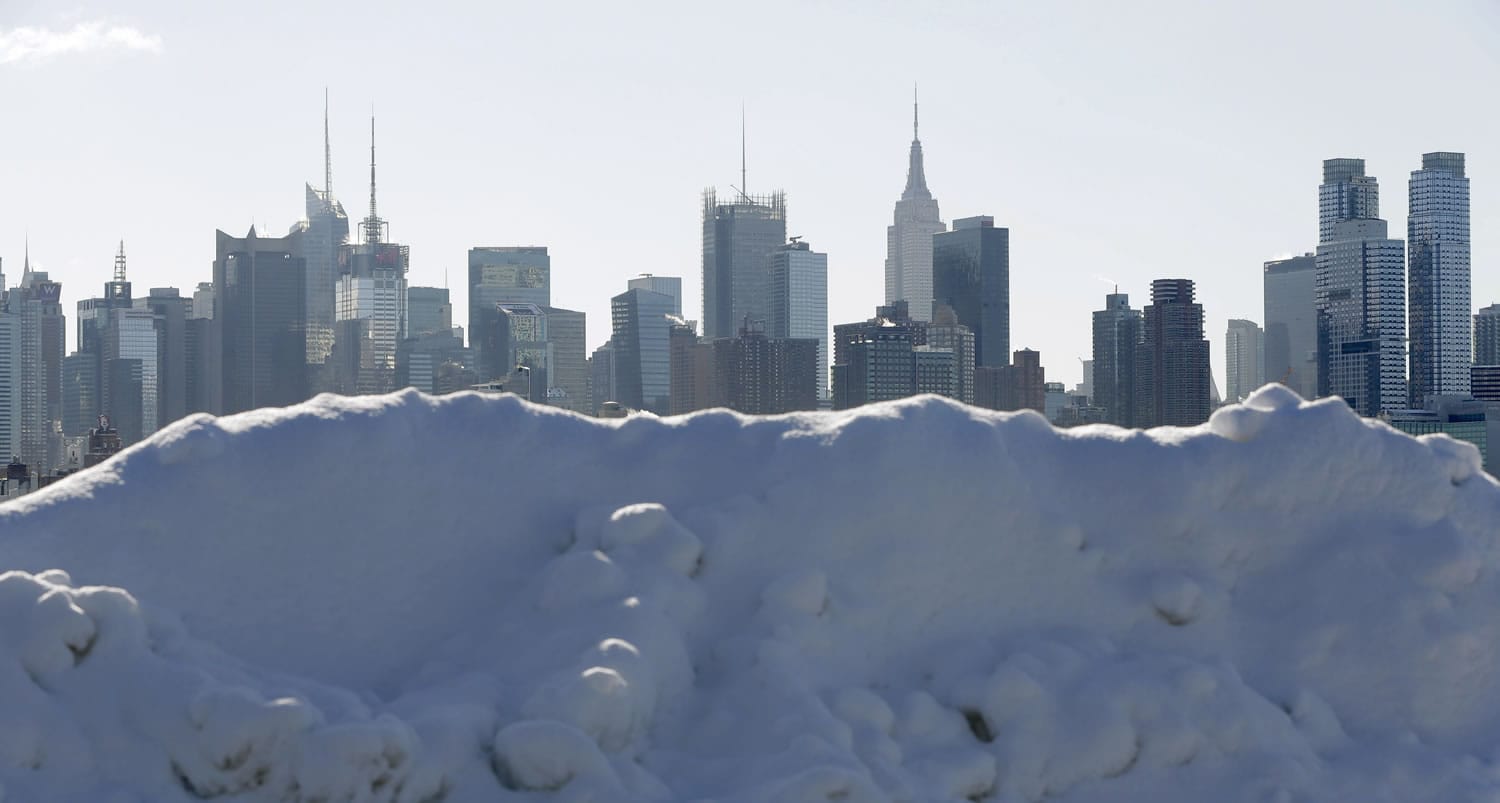 Piles of snow line the waterfront overlooking the New York City skyline Friday in Weehawken, N.J.
