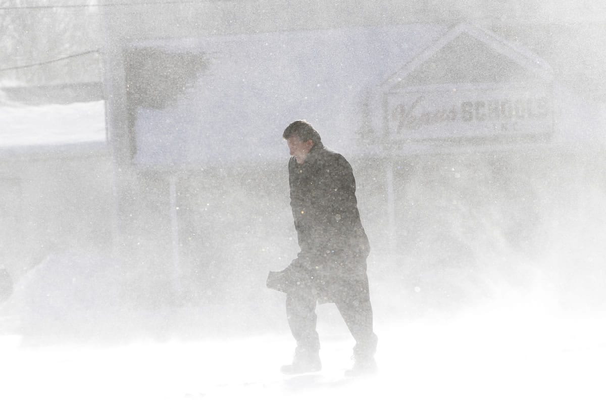 A pedestrian walks through drifting snow Friday in Sharon Hill, Pa., outside Philadelphia.