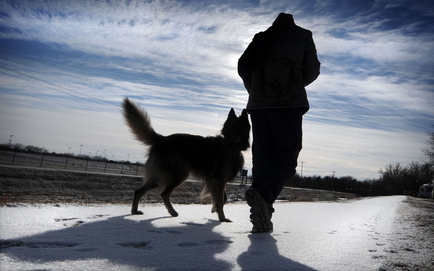 Bundled against the cold, Kat Farres walks Monday morning in Salina, Kan., with her dog, Varro. &quot;We walk every day we possibly can,&quot; Farres said.