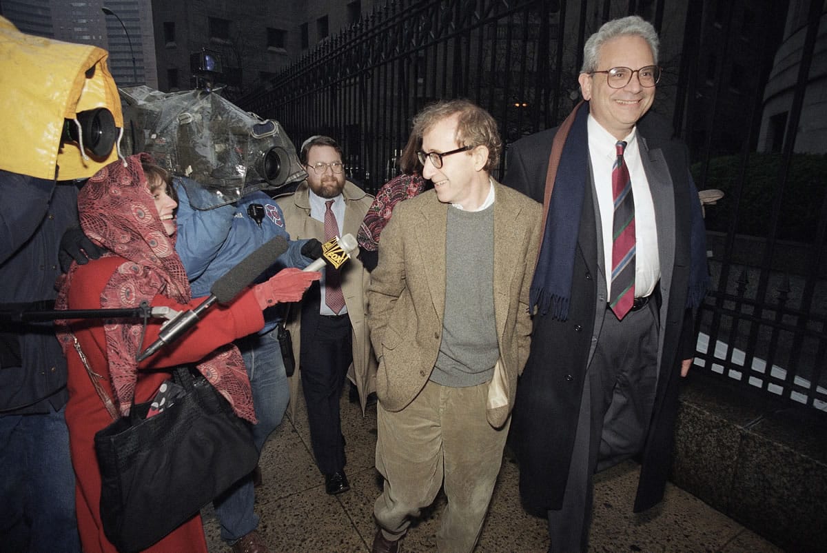 Director Woody Allen trading grins with a pursuing television reporter as he arrives at State Supreme Court in Manhattan, New York, for a 1993 hearing in which he requested more liberal visitation rights with his children during his ongoing dispute with ex-lover actress Mia Farrow.
