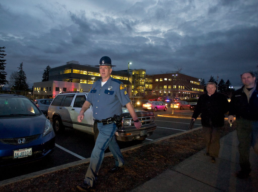 A Washington State Patrol sergeant walks through the parking lot of the Center for Community Health as officers from multiple agencies respond to a report of shots fired on Tuesday.