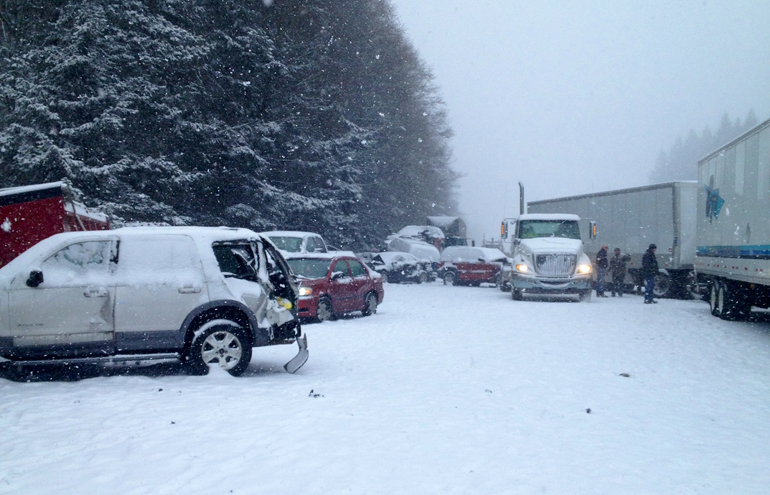 At least one person died and 15 vehicles were totaled Thursday morning during a pileup crash that closed Interstate 5 near Battle Ground as a snow storm descended on Clark County.